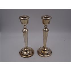 Pair of modern silver mounted candle sticks, with taping stems and upon beaded circular filled bases, hallmarked P H Vogel & Co, Birmingham 1975, H21cm