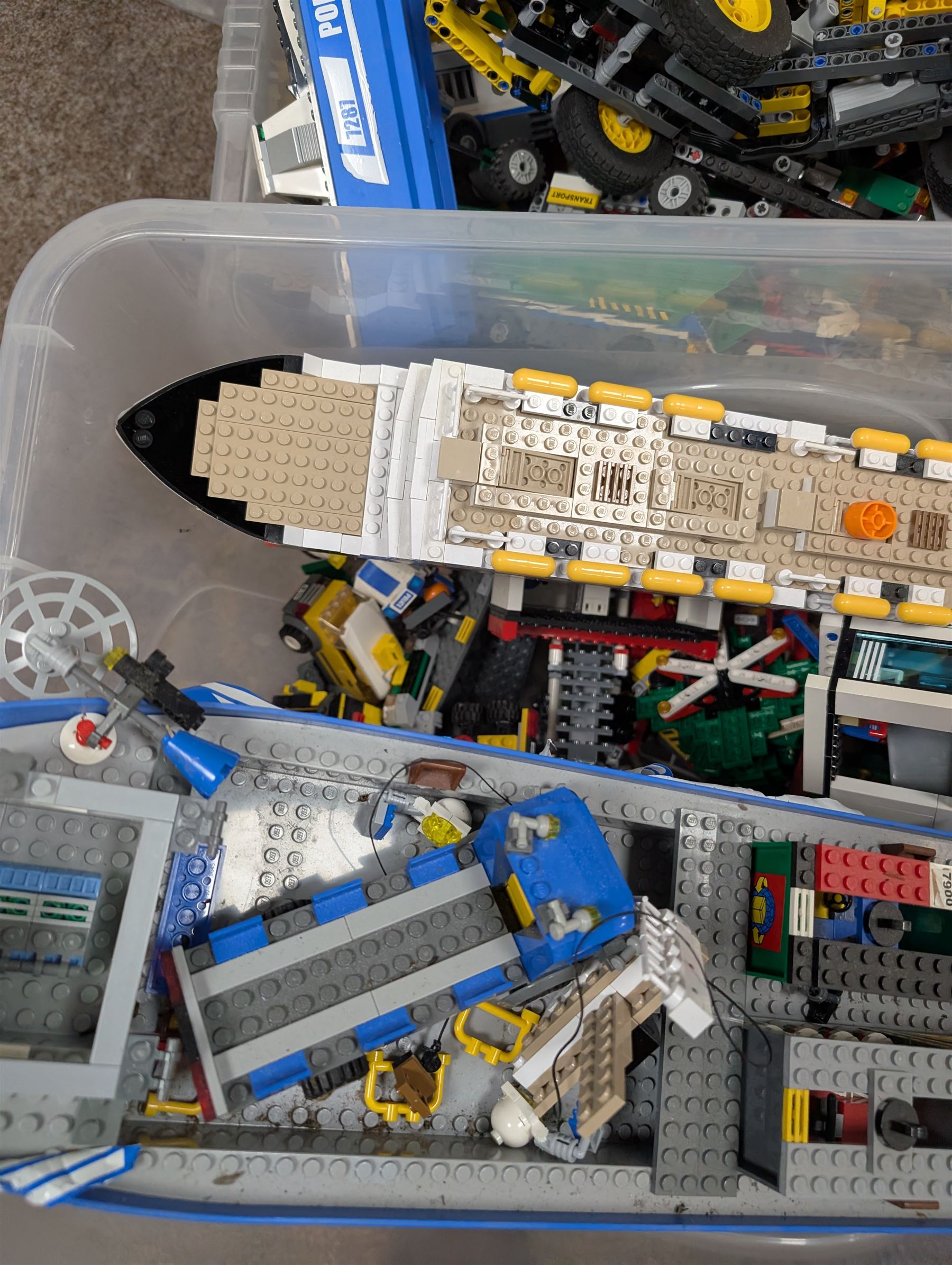 Two boxes of partially built Lego vehicles, including Lego Technics Dumper Truck no. 8264, Titanic, container ships, police boat, smaller police vehicles, etc