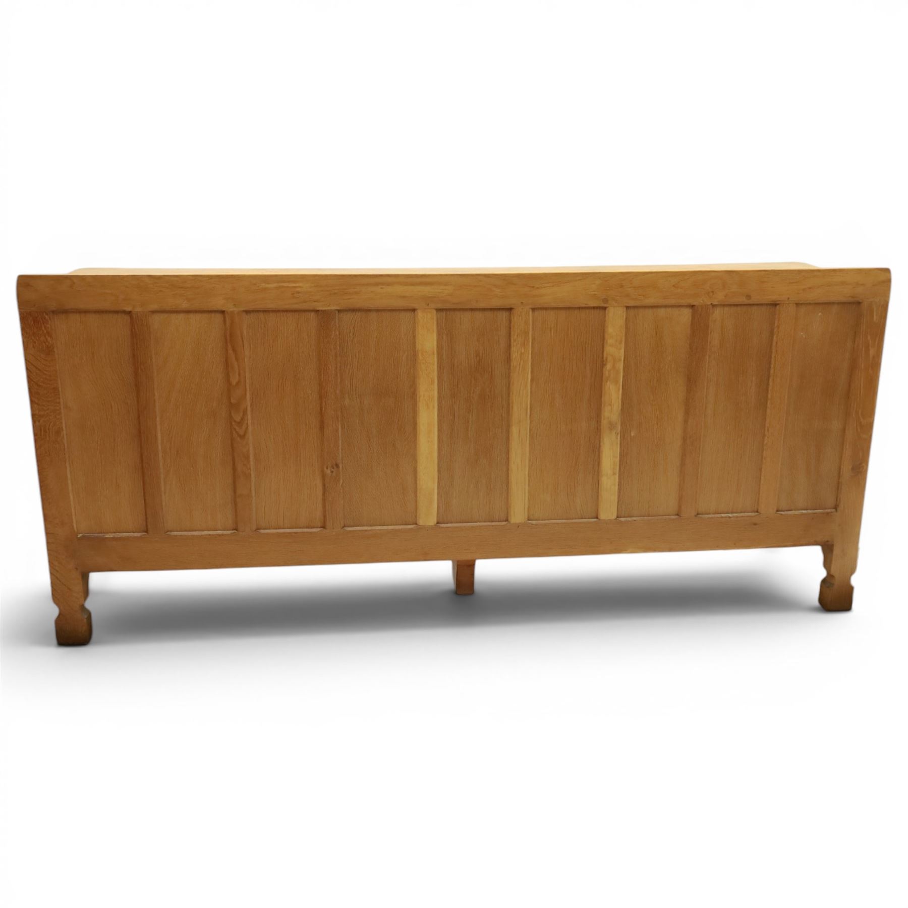 Mouseman - large adzed light oak sideboard, the rectangular top with raised galleried back, fitted with three central drawers flanked by panelled cupboards enclosing shelves, with wrought iron fittings, raised on octagonal feet, with signature carved mouse, by the workshop of Robert Thompson, Kilburn