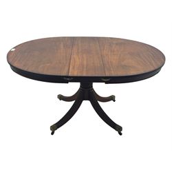 Regency design mahogany extending dining table, circular top with reeded edge and pull-out mechanism to accommodate additional leaf, raised on a carved central baluster column with acanthus detailing, supported by a quadruple reeded splay base terminating in brass caps and castors

