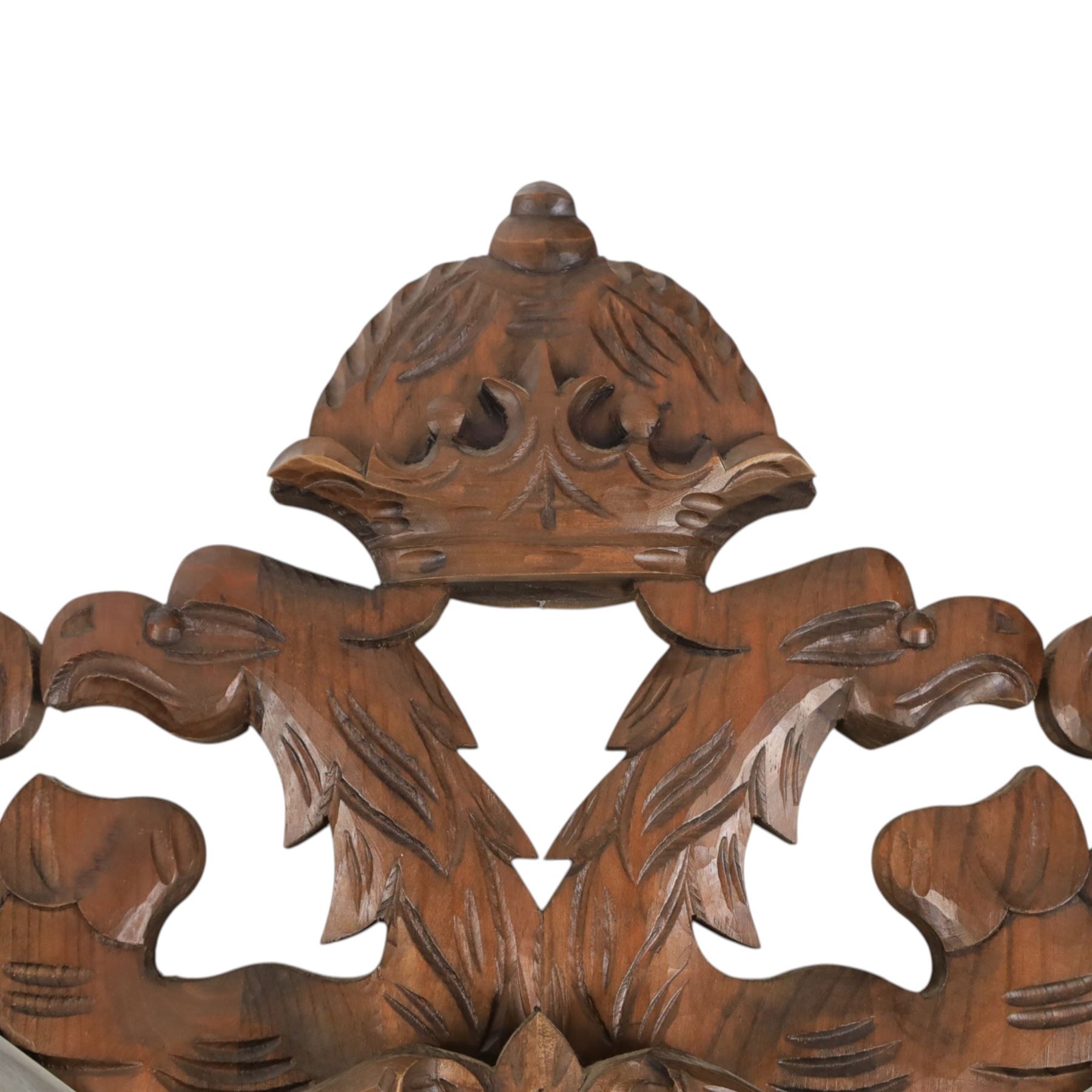 Carved wooden wall plaque, decorated with foliate scrolls, with two reproduction swords attached, together with five other wooden plaques with foliate scrolls and shields