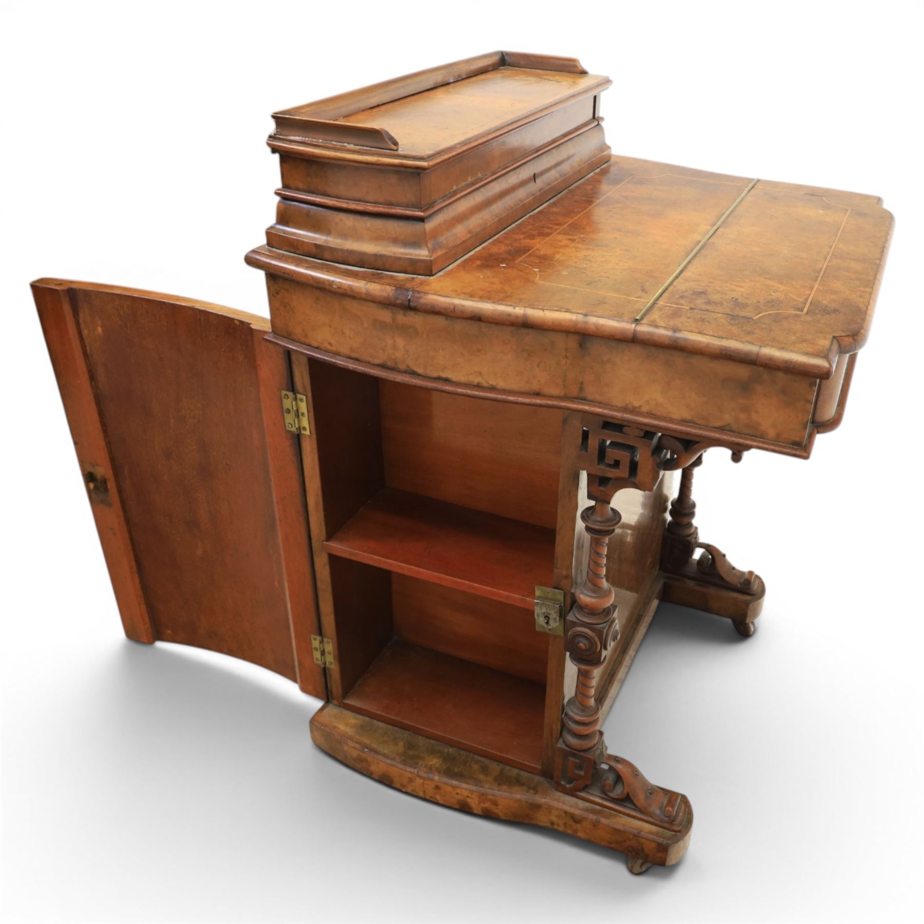 Victorian burr walnut Davenport, with hinged stationary top and slope, pull out writing surface with tooled green leather inset top, carved and turned front supports, flanked by two cupboard doors, raised on castors 