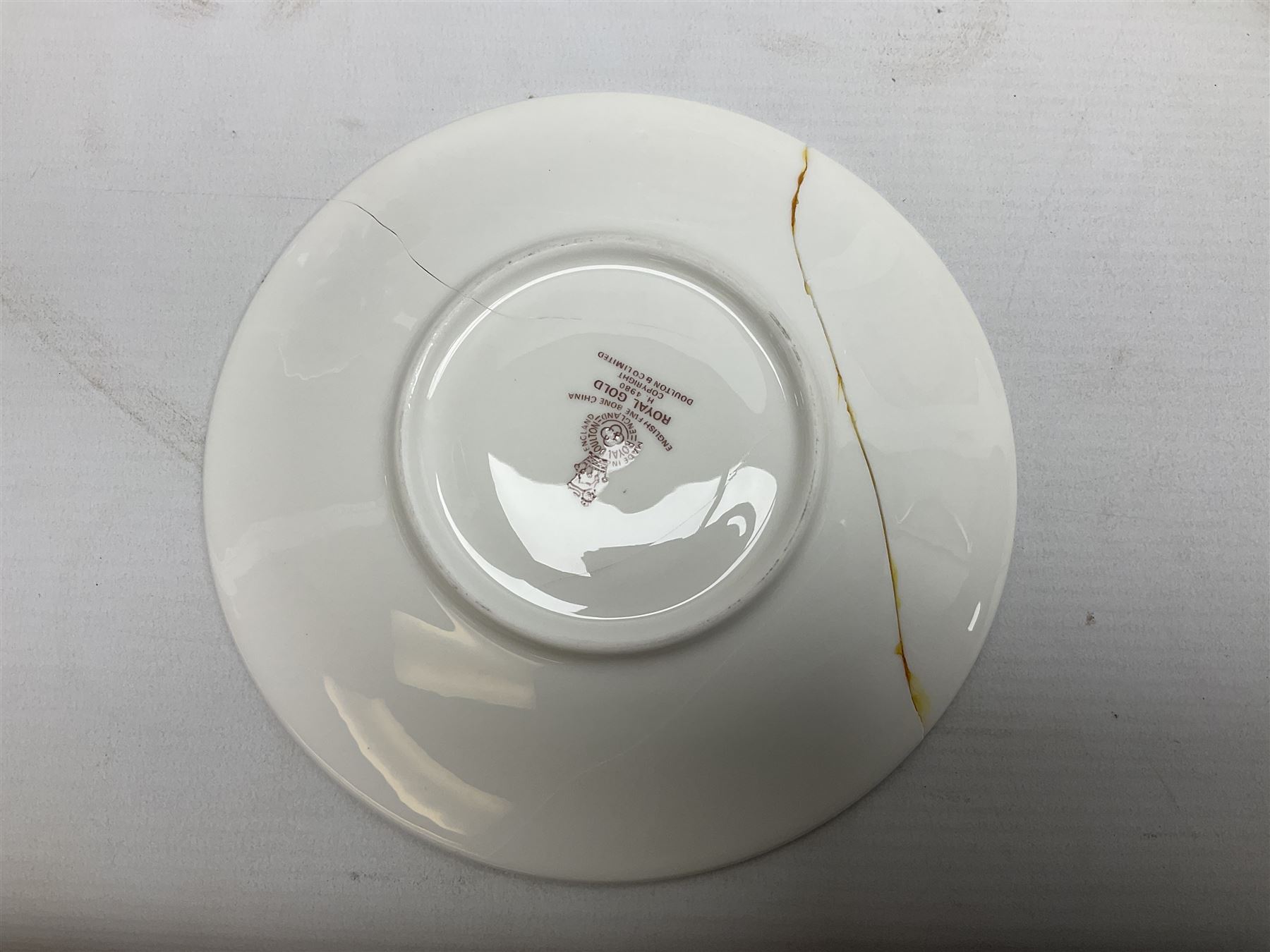 Royal Doulton Royal Gold pattern tea and dinner service for eight, comprising dinner plates, side plates, tea plates, soup bowls, sauce boat and saucer, dessert bowls, coffee cans and saucers, teacups and saucers and two lidded tureens