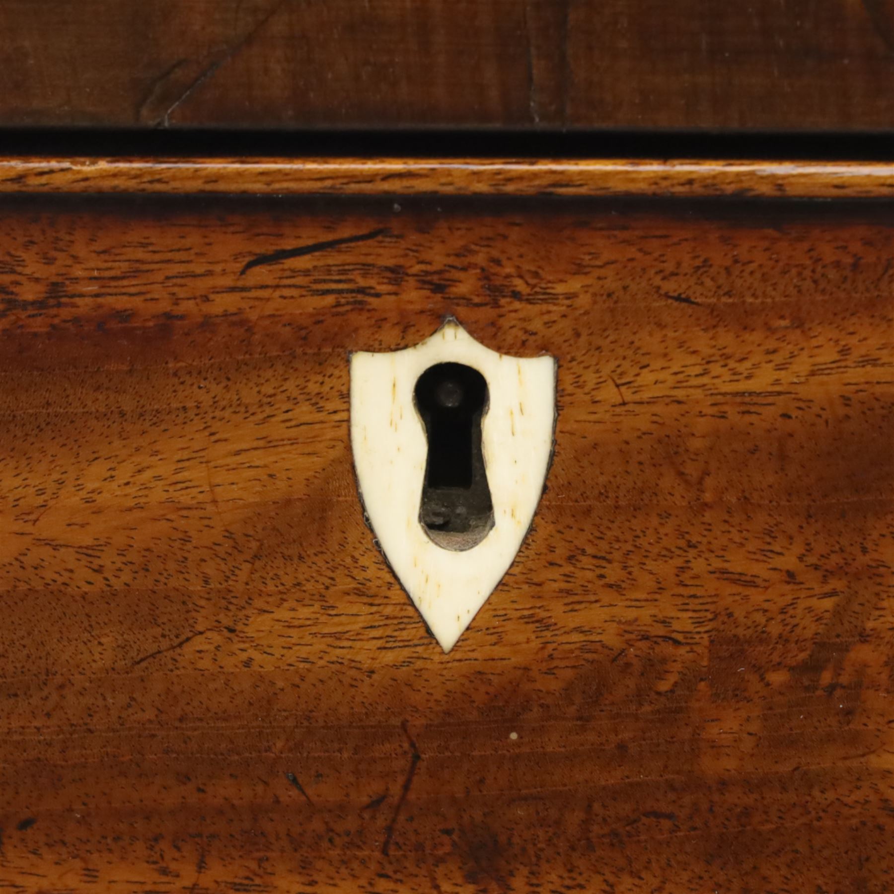 19th century mahogany bow fronted chest, the moulded top over four long cock-beaded drawers with brass swan neck handles and shield shaped bone escutcheons, flanked by reeded uprights, raised upon shaped bracket feet