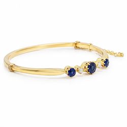 Early 20th century 18ct gold sapphire and diamond hinged bangle, the front set with three round cut sapphires and spaced by two old cut diamonds, total sapphire weight approx 1.15 carat