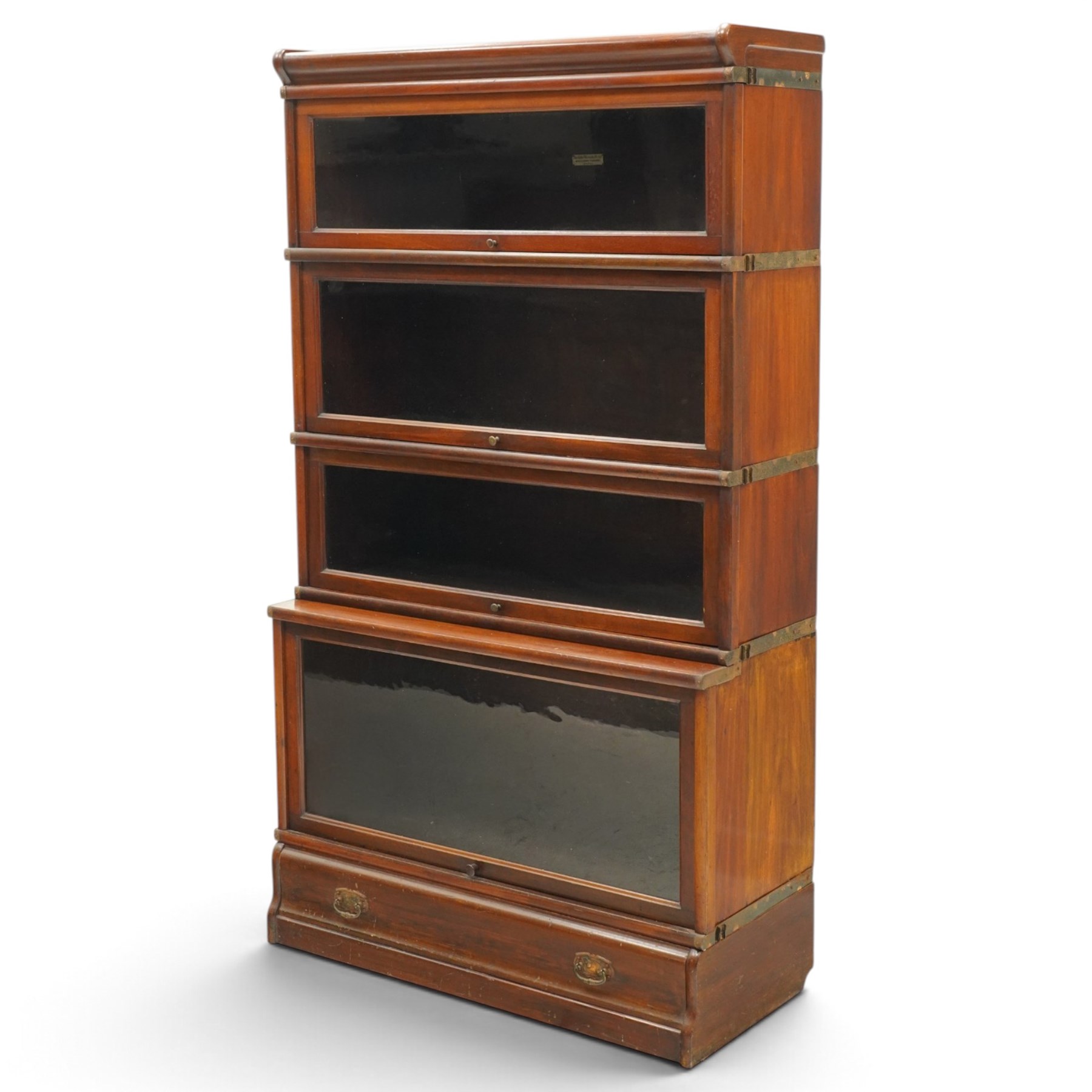 Globe Wernicke - early 20th century mahogany four-tier stacking library bookcase, the shelves fitted with glazed up-and-over doors, fitted with single drawer to the skirted base