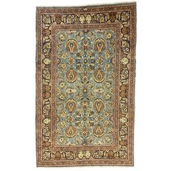 Central Persian Qum pale blue ground rug, the field decorated with stylised plant motifs surrounded by trailing foliate vine patterns in a symmetrical format, the multi-band guarded indigo border decorated with repeating flowerheads 