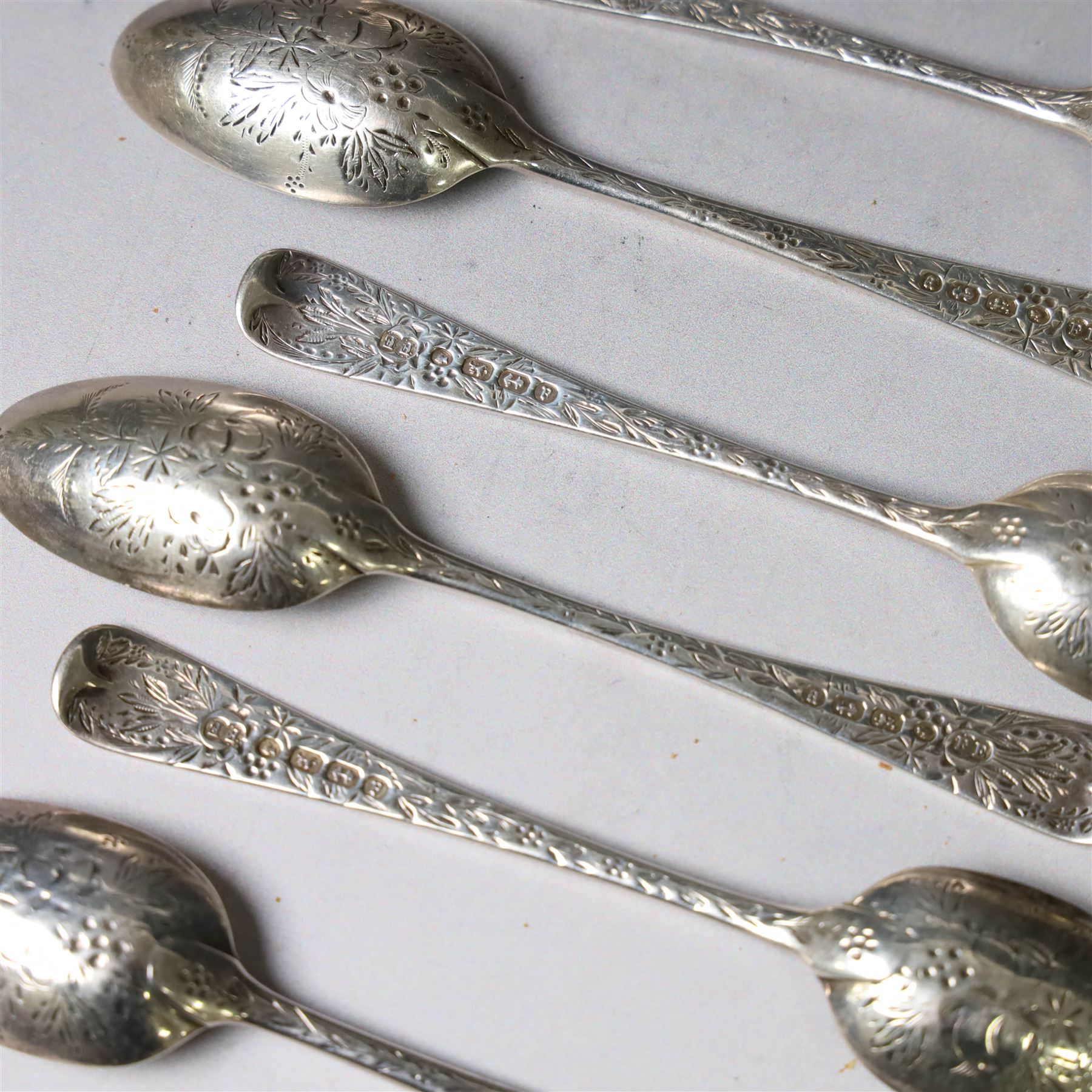Eleven Victorian silver teaspoons, profusely engraved with floral decoration throughout with family crest to terminal, hallmarked Elkington & Co, Birmingham 1875