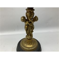 Late 19th/early 20th century brass oil lamp, the central column modelled with two cherubs, supporting the reservoir with frilled glass shade, raised upon circular base, H71cm