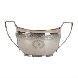 George III silver three piece tea service, comprising teapot with ivory scroll capped curved handle and ivory finial to the hinged cover, twin handled open sucrier with gilt interior, and cream jug with gilt interior, each of oval form with rounded sides, the bodies engraved with central monogram within a seaweed wreath, between engraved foliate bands, hallmarked John Emes, London 1801, teapot including handle H17cm

This item has been registered for sale under Section 10 of the APHA Ivory Act