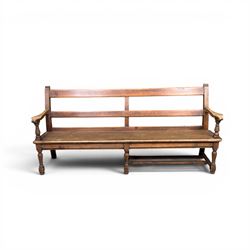 Early 20th century pine and oak bench seat, stained pine rail back frame with shaped oak arms