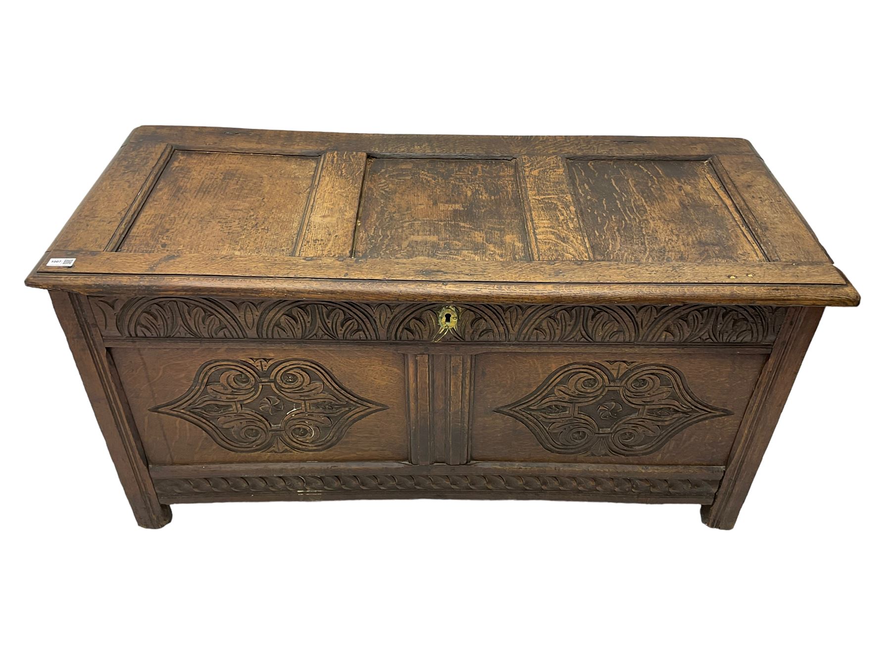 18th century oak blanket chest or coffer, rectangular hinged top with three panels and moulded edge, frieze carved with lunette and acanthus leaf decoration, two front panels carved with scrolling motif, raised on stile supports