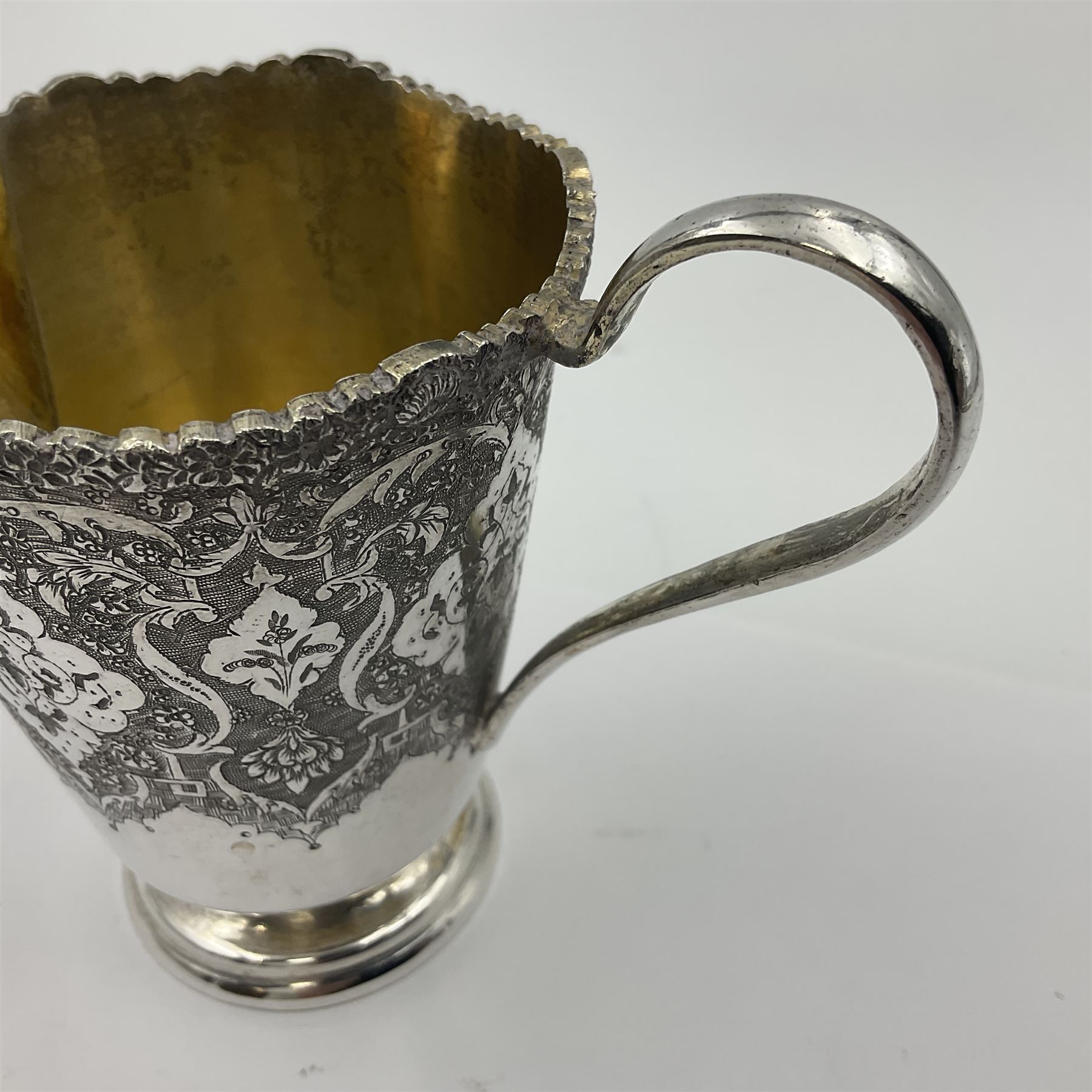 Early/mid 20th century Persian silver tea service, comprising circular serving tray, teapot, twin handled sucrier and cover, milk jug, five tea glasses with six silver holders, six tea spoons, and pair of sugar tongs, each profusely chased with foliate arabesque decoration, each bearing marks including 84 for 840 fineness, tray D40cm, teapot H16cm