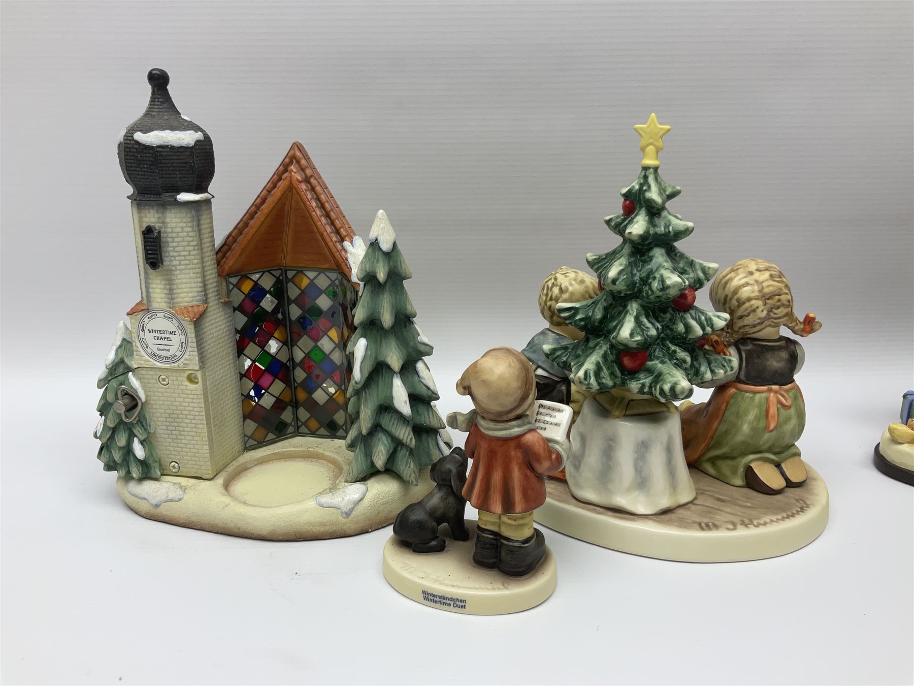 Eight Christmas Hummel figures by Goebel, to include Wintertime Chapel candle holder, Winter Fun, Christmas Morning, Christmas Time and Gingerbread Lane, tallest H21cm