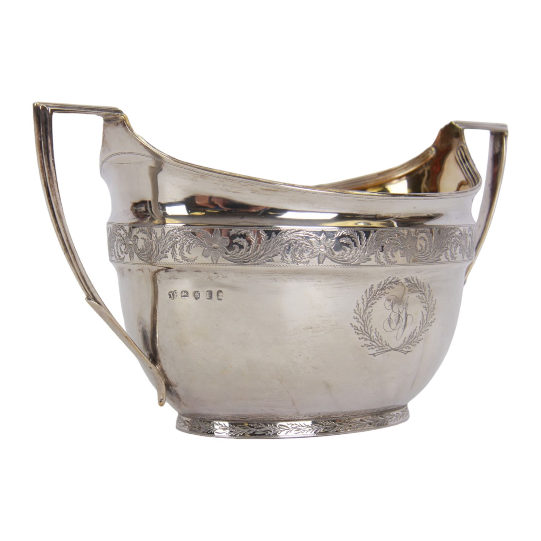 George III silver three piece tea service, comprising teapot with ivory scroll capped curved handle and ivory finial to the hinged cover, twin handled open sucrier with gilt interior, and cream jug with gilt interior, each of oval form with rounded sides, the bodies engraved with central monogram within a seaweed wreath, between engraved foliate bands, hallmarked John Emes, London 1801, teapot including handle H17cm

This item has been registered for sale under Section 10 of the APHA Ivory Act