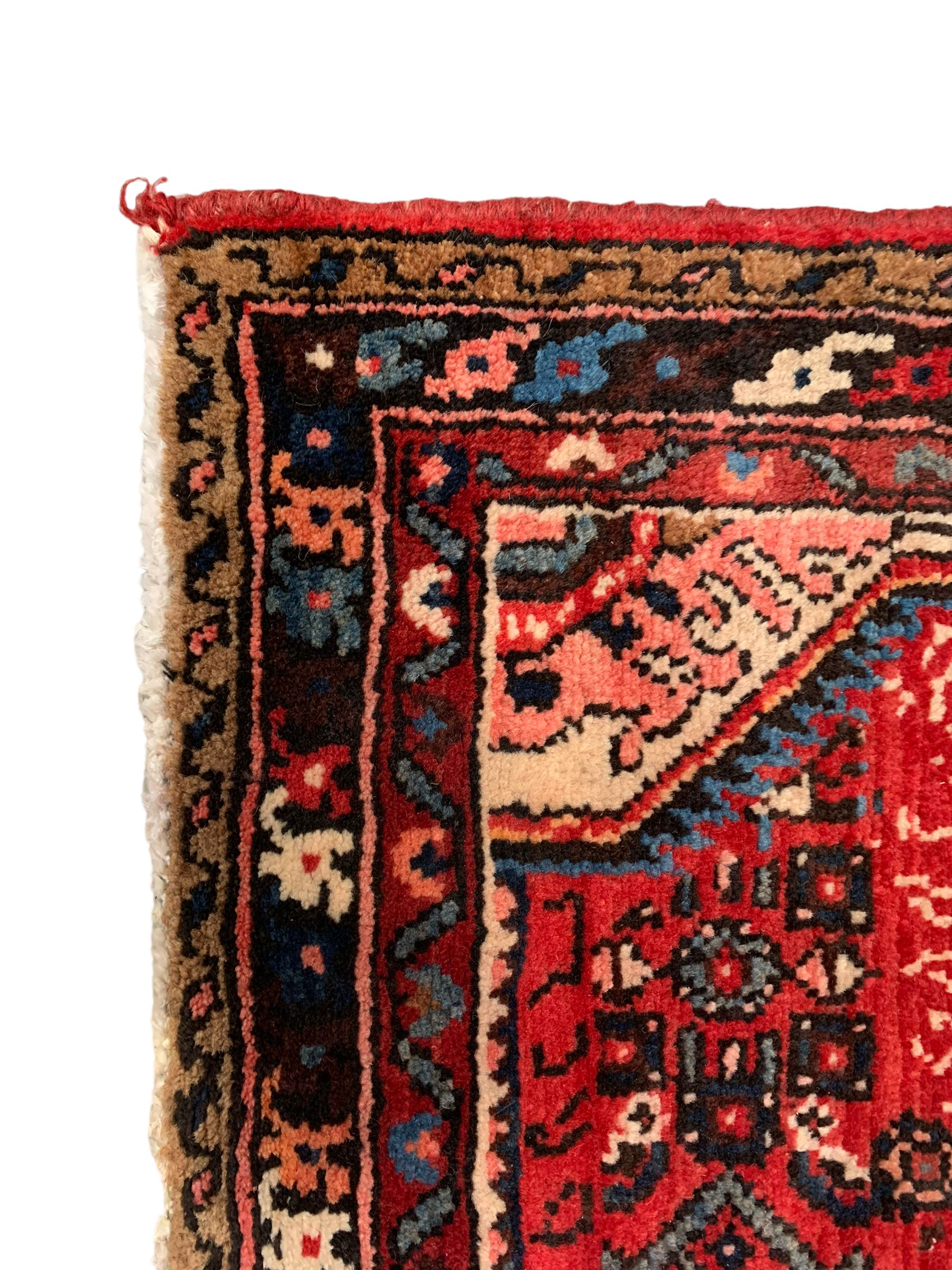 Persian crimson ground runner, the field decorated with Herati motifs,  three-band border, the main band decorated with repeating flowerheads 