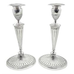 Pair of George III silver Adam style candlesticks, each of oval fluted form, the bases with beaded rim and stylised border, conforming borders to top of stem and removable nozzle, hallmarked William Abdy I, London 1787, H28.5cm