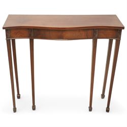 Edwardian mahogany serpentine side table or console table, figured frieze decorated with applied carvings, on six square tapering supports with spade feet