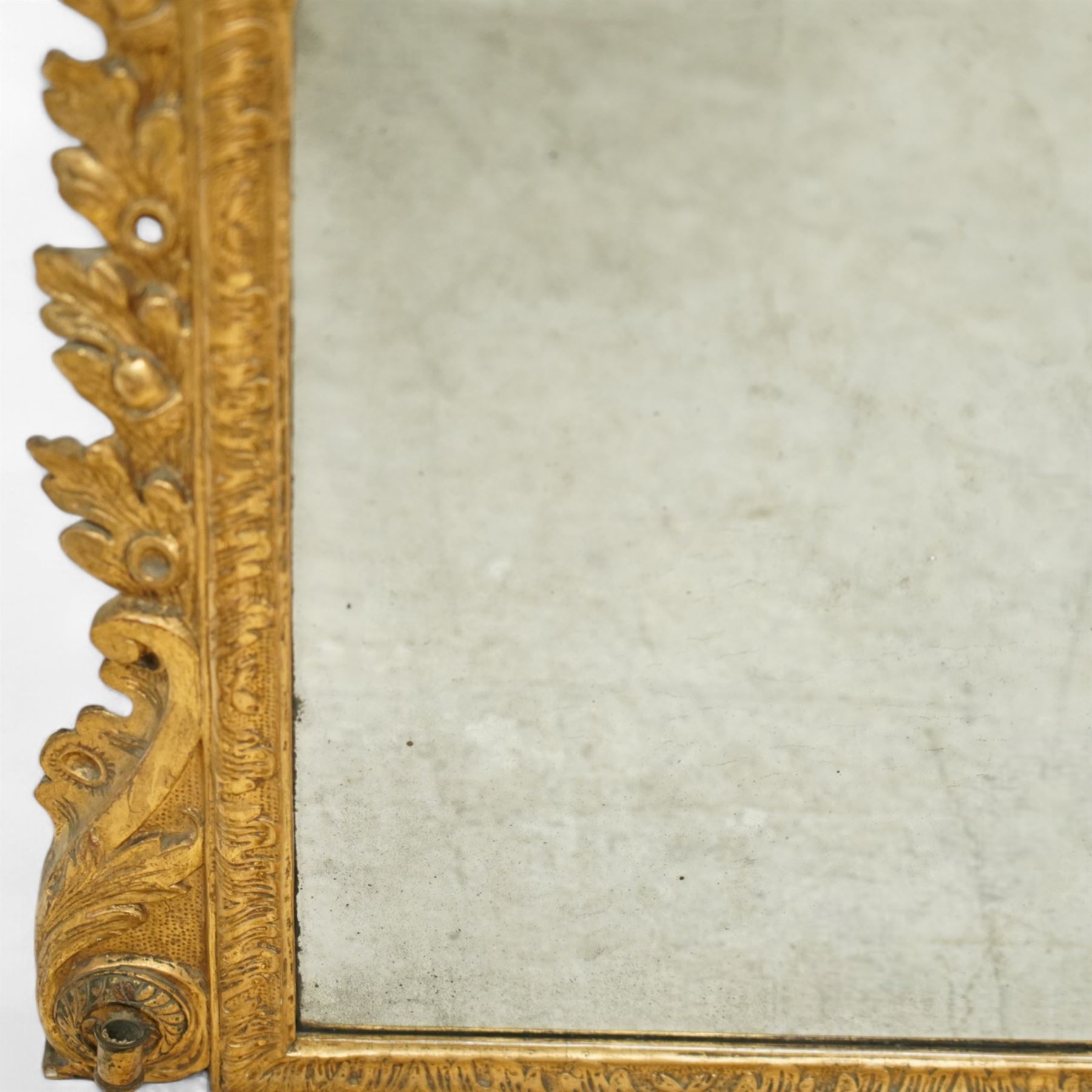 19th century George III style giltwood overmantel mirror, the rectangular bevelled plate within a moulded frame decorated with acanthus leaf and floral scroll carving to the corners, and sides flanked by two girandole sockets 