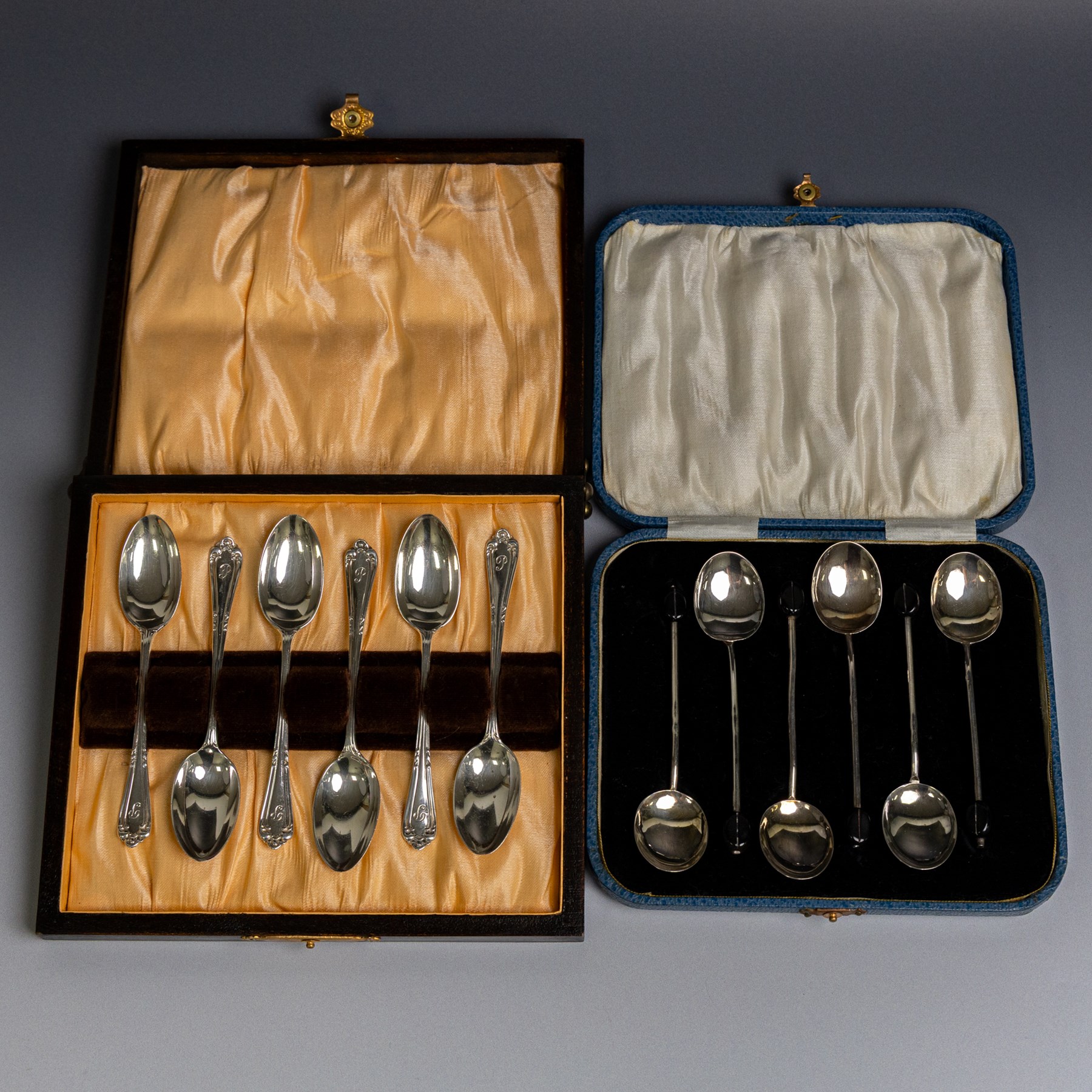 Two sets of early 20th century cased silver coffee spoons, comprising a set of six with scrolling decoration and engraved initials and a set of six coffee bean spoons, all hallmarked 