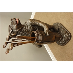  20th century Black Forest umbrella stand in the form of a snarling bear in a cap holding a golf club bag, on a rocky base, H120cm with a collection of hickory shafted woods and irons   