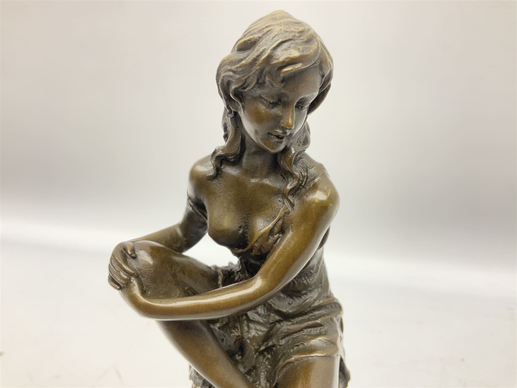Art Deco style bronze modelled as a female figure, holding her knee, seated upon a chair, after 'Pierre Collinet', H28cm