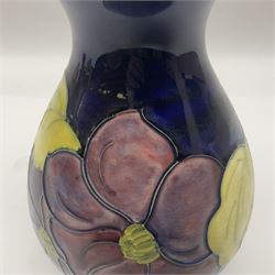 Moorcroft Clematis pattern vase of baluster form, upon a blue ground, with painted and impressed marks beneath, H22cm