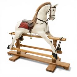 Late 20th century polychrome painted rocking horse, modelled in dapple grey finish with real hair mane and tail, leather tack and saddle, stirrups, raised on a natural wood safety trestle base