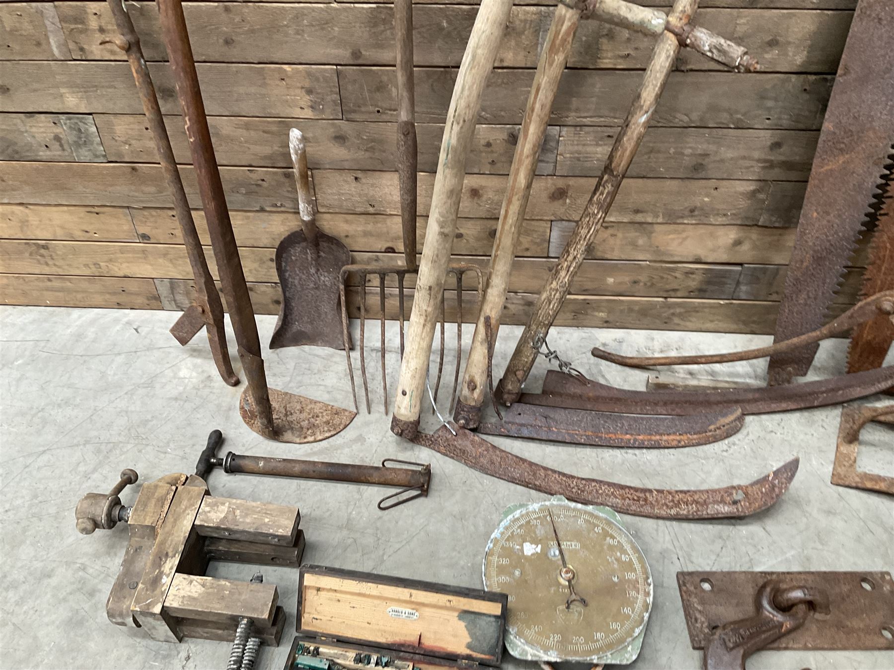 Large quantity of vintage hand tools including scales, scythes, saws etc