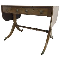 Regency mahogany sofa table, rectangular crossbanded top with twin drop-leaf ends, fitted with single drawer and one faux drawer, raised on shaped end supports united by ring turned stretcher