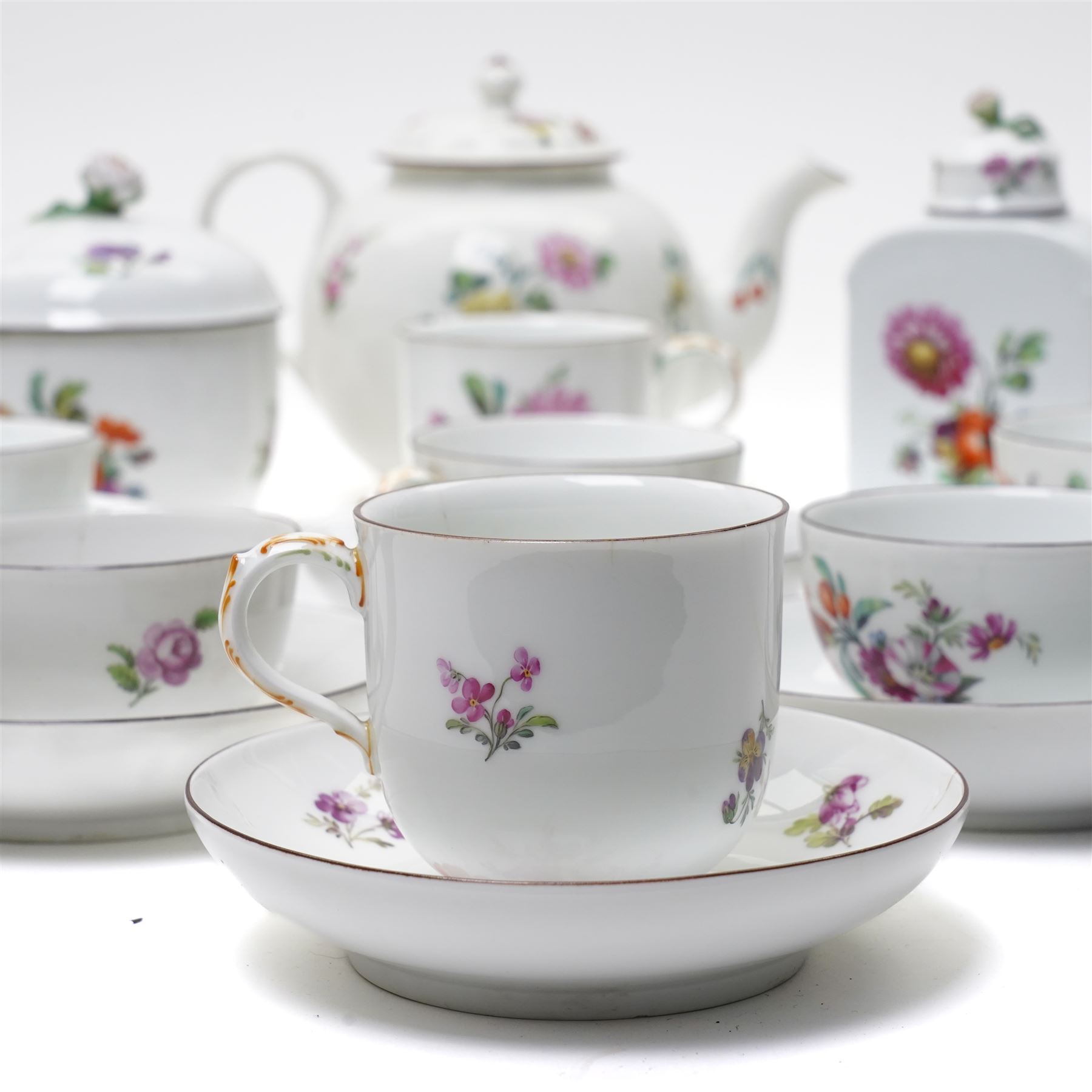 18th century Berlin part tea and coffee service circa 1780 painted with sprays of Spring flowers comprising four tea cups, five coffee cups,  six saucers, tea pot, tea caddy and sucrier and cover  