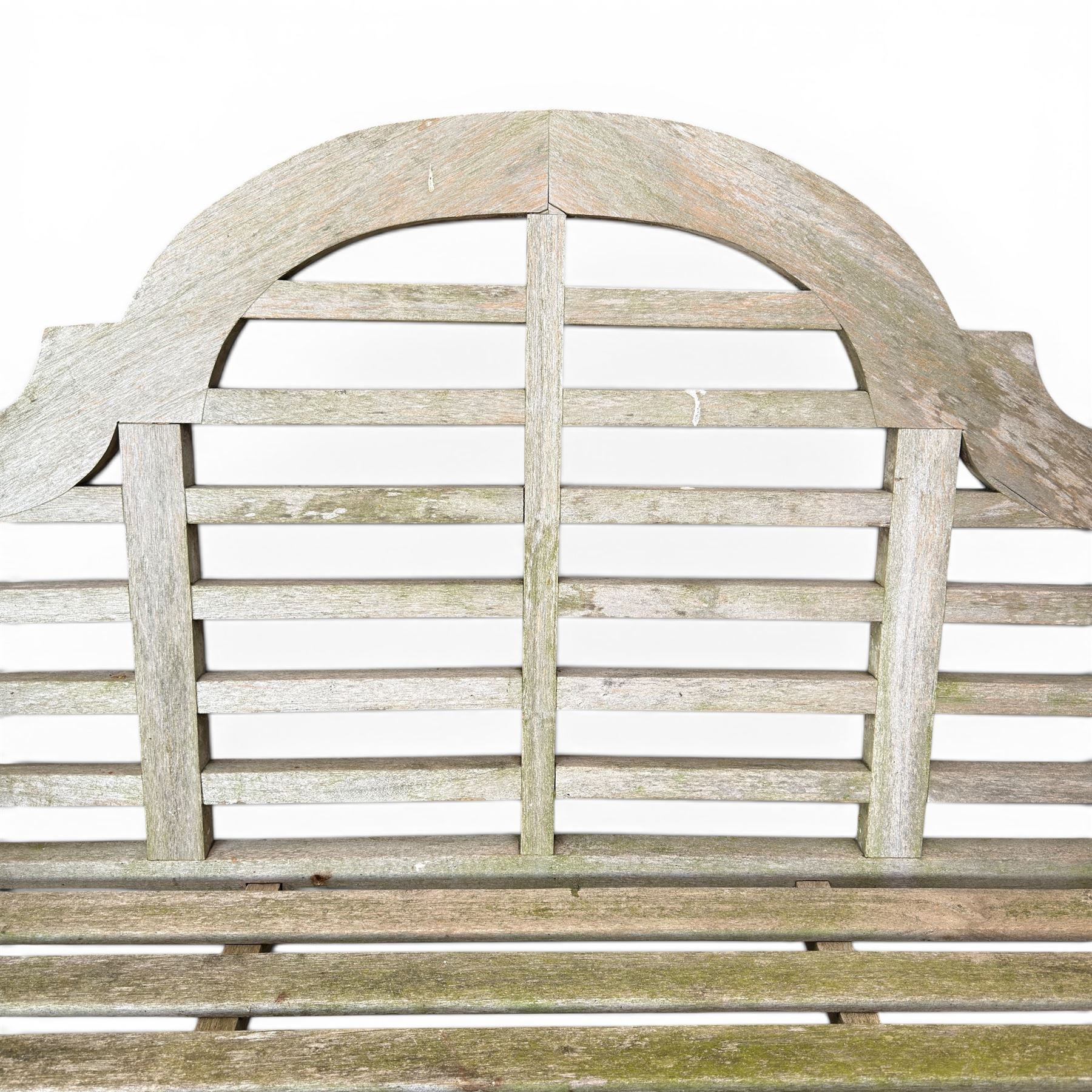 Lutyens design weathered teak garden bench with matching two-tier table, the bench with shaped arched and slatted back over rolled arms and slatted seat