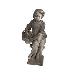 Haddonstone - weathered cast stone garden statue of a boy holding a basket of grapes, modelled with curled locks of hair wearing a tunic and breeches leaning against a naturalistic tree stump, on square base