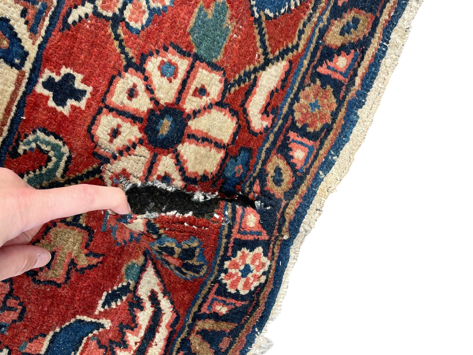 Persian blue ground carpet, the field divided up into panels by trailing bands with flower heads, each panel decorated with palmettes and stylised plant motifs, the border decorated with further palmettes, within floral pattern guard stripes 