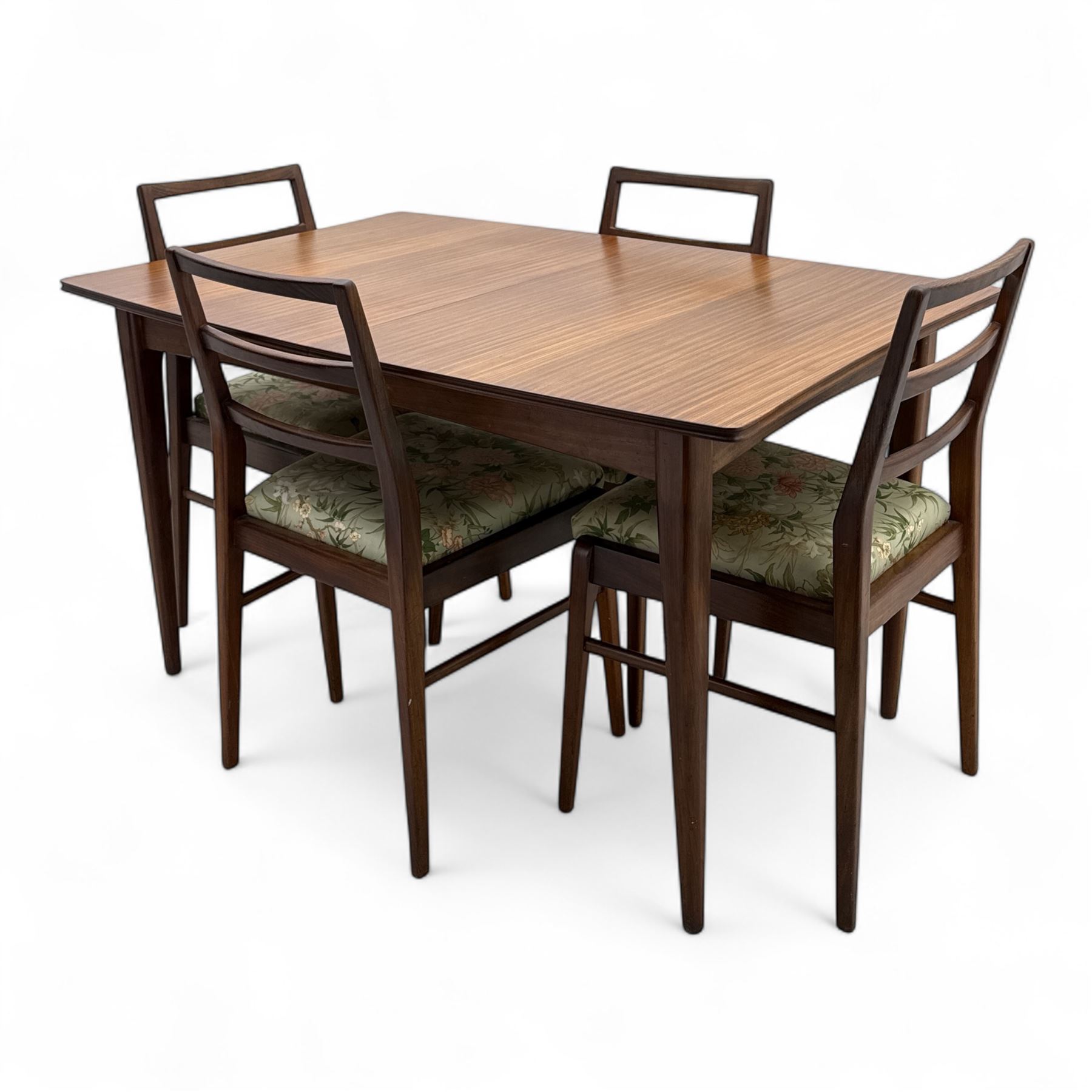 Richard Hornby for Fyne Ladye - mid-20th century afromosia teak dining table, tapered rectangular top with fluted edge and recess for spare leaf, raised on slender legs, teak framed chairs, of ladder back design, with drop-in seat, upholstered seat, with tapered front legs and slightly raked rear legs, retailed by Heals of London, table extended width 181cm depth 86cm height 74cm - chairs width 48cm depth 41cm height 87cm 