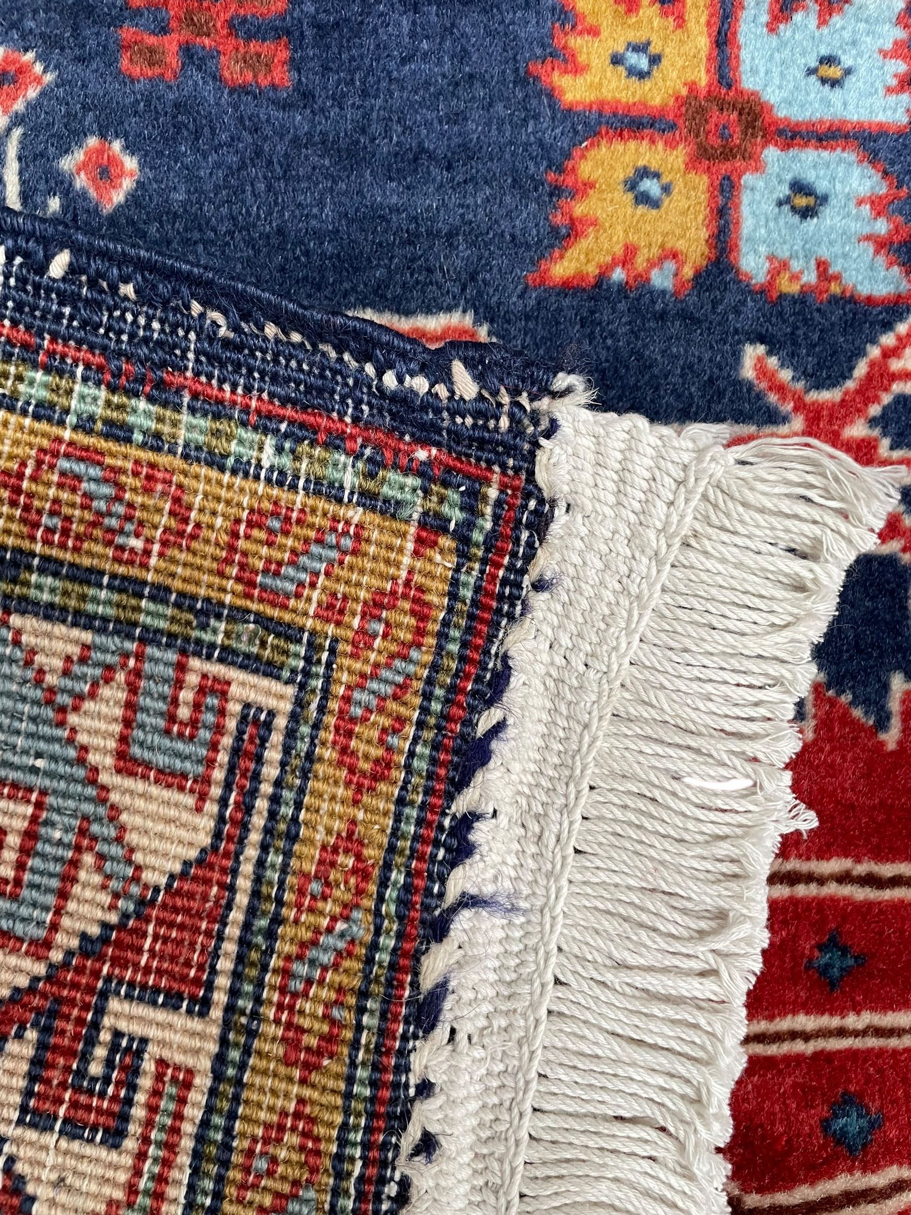 Persian Ardabil indigo ground rug, four interconnected lozenge medallions surrounded by ewer, bird, dragon, camel and geometric motifs, hooked border within guard stripes 