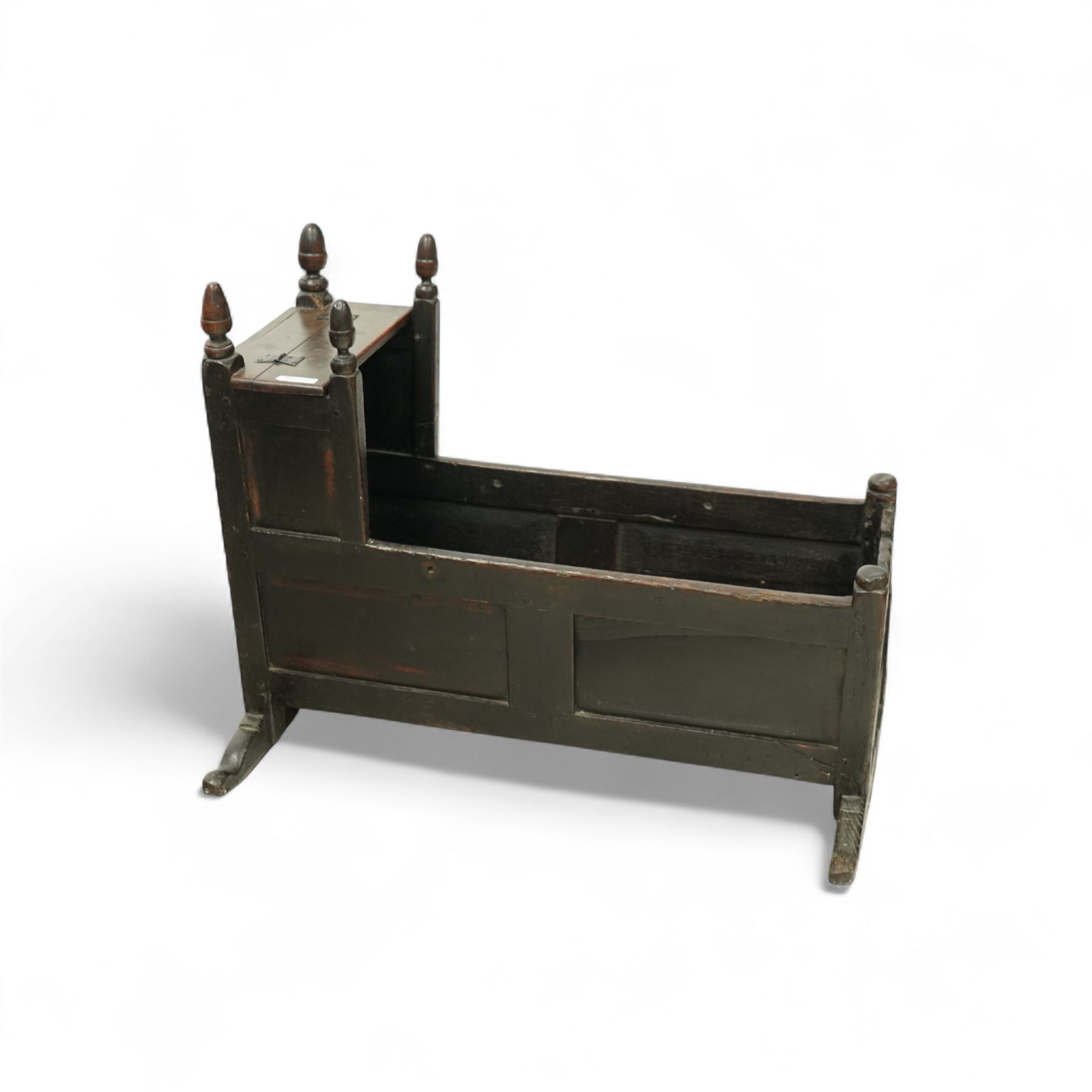 Early 18th century oak cradle dated AD 1710 and late 19th century kitchen chair, the cradle of pegged construction with shaped headboard and turned finials, raised on curved rockers (H 75cm, W 94cm, D 62cm), the chair with spindle back, turned supports and circular seat (H 89cm, W 42cm, D 47cm)