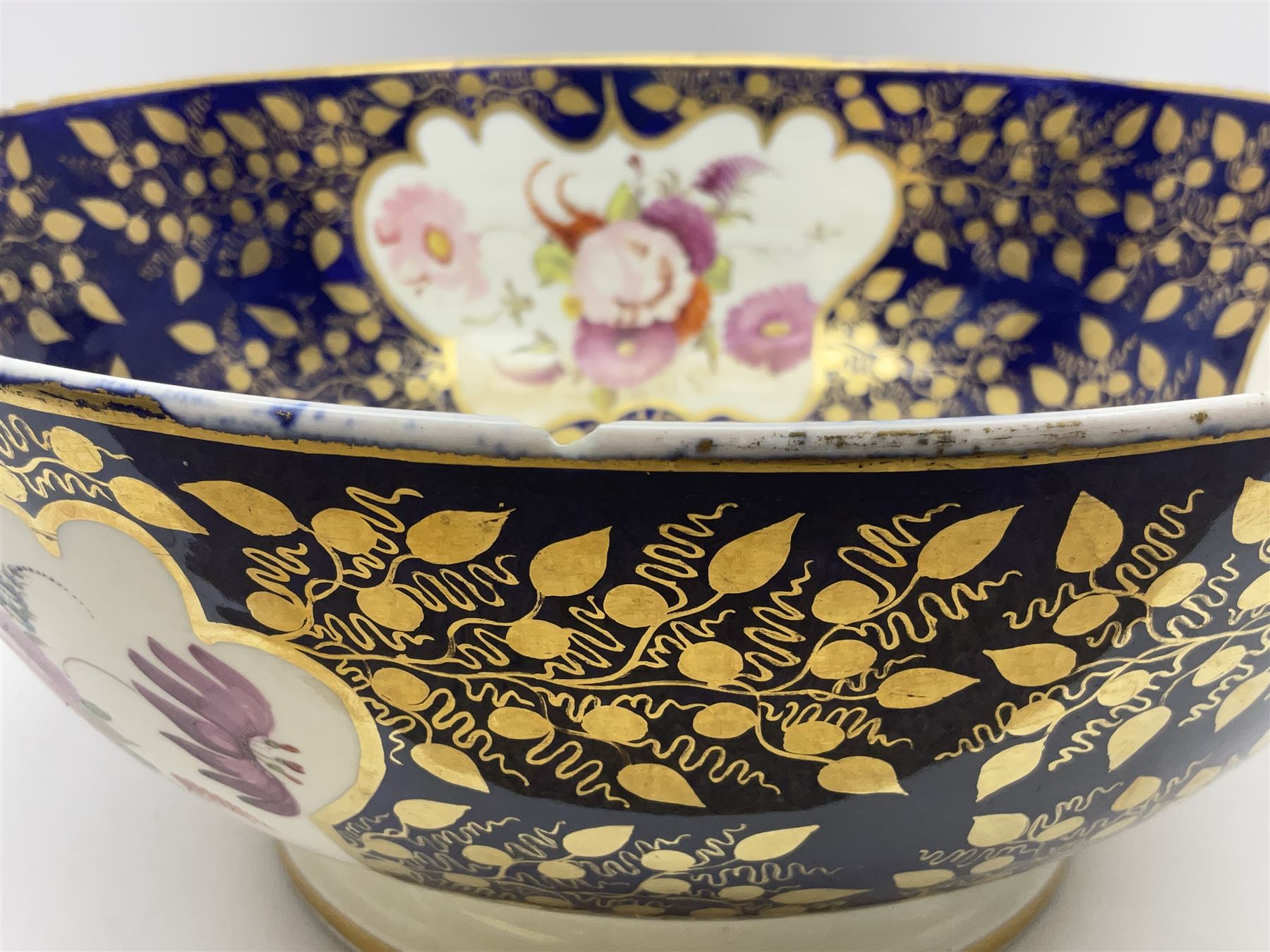 19th century continental bowl, decorated with hand painted floral sprays amongst gilt foliate decoration on a cobalt blue ground, D27.5cm