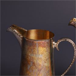 Two graduating silver milk jugs, each of tapering cylindrical form, with engraved central cartouche to body and upon three paw feet, hallmarked Christopher Nigel Lawrence, London 1988, tallest H13cm