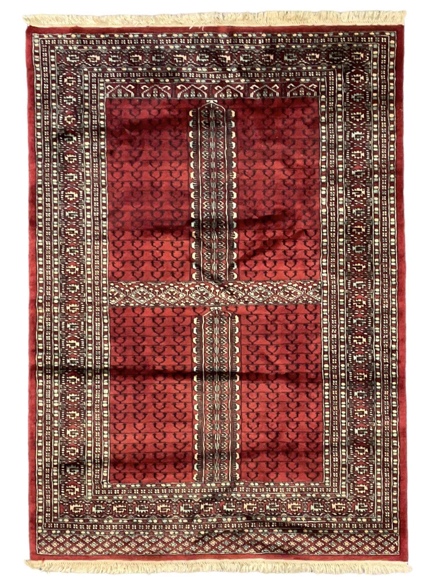 Tekke Ensi crimson ground rug, the quartered field decorated with candelabra motifs, multi-guarded border with repeating geometric hexagonal lozenges in blue and ivory