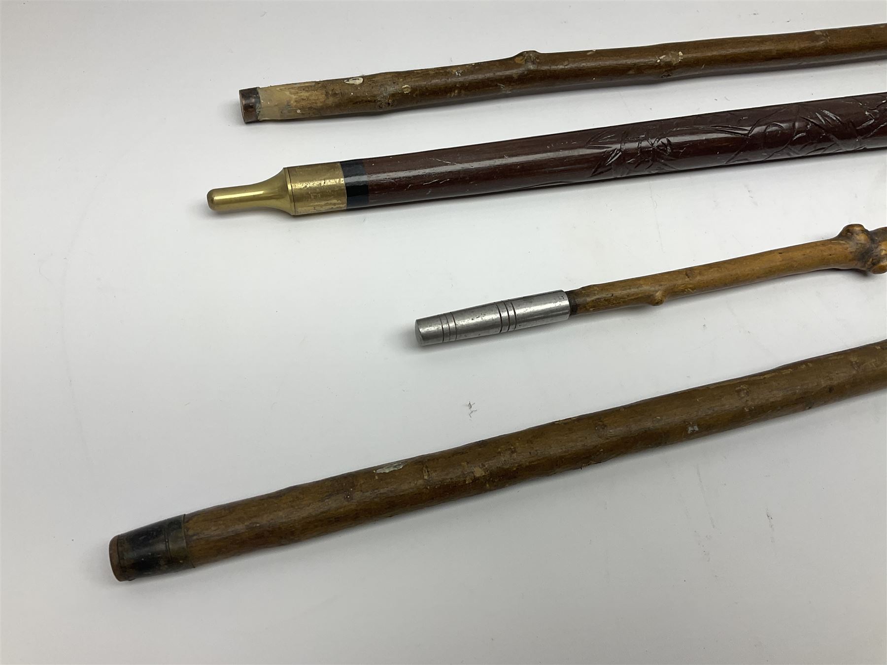 Four wooden walking canes, including a carved mahogany snooker cue example, tallest H86cm