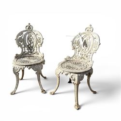 Pair of white painted cast metal garden chairs, ornate reclined backs, circular pierced se...