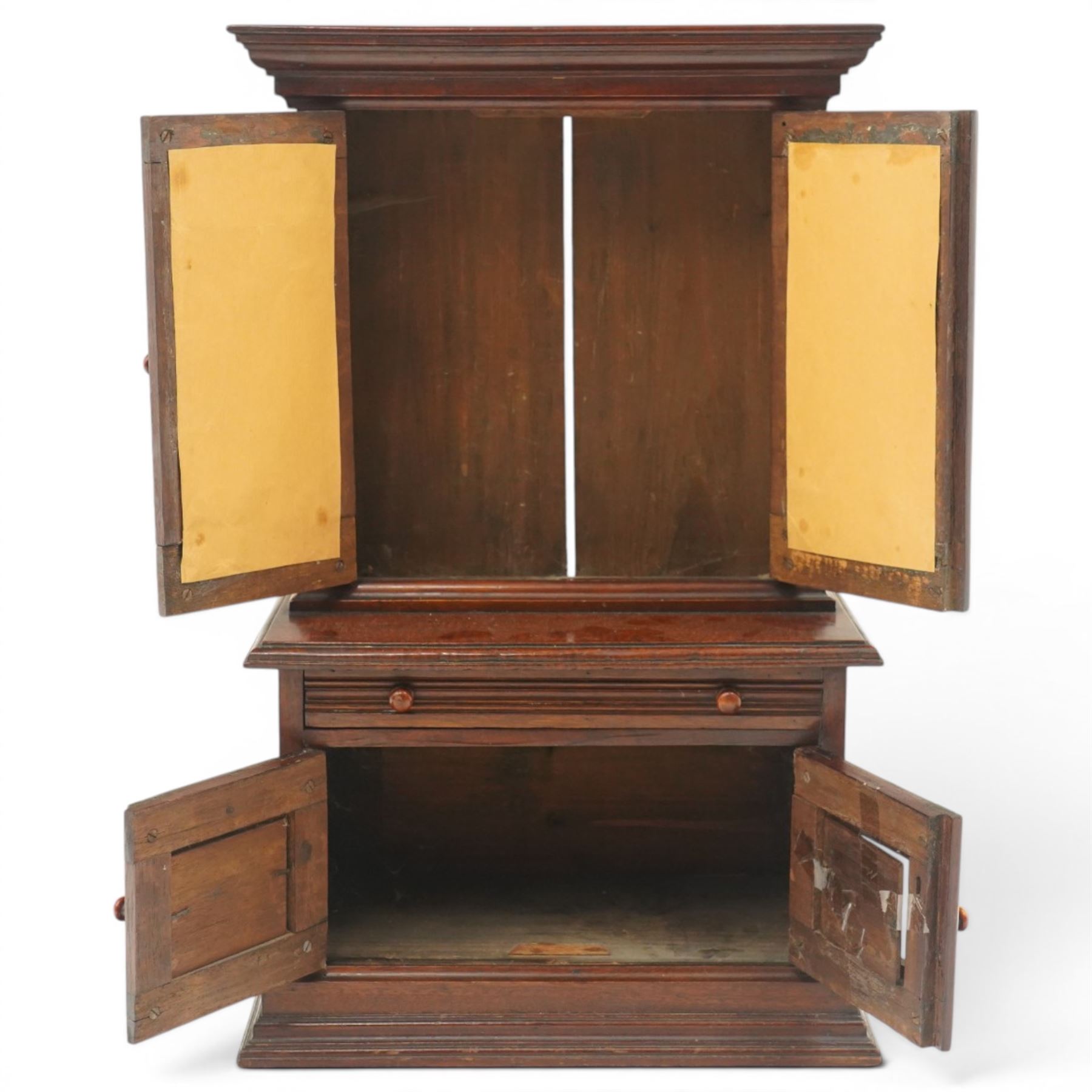 Miniature Victorian mahogany apprentice's cabinet-on-chest, the projecting cavetto cornice over two doors with bevelled mirror plates, the base fitted with single reeded frieze drawer over a panelled cupboard, on stepped plinth base