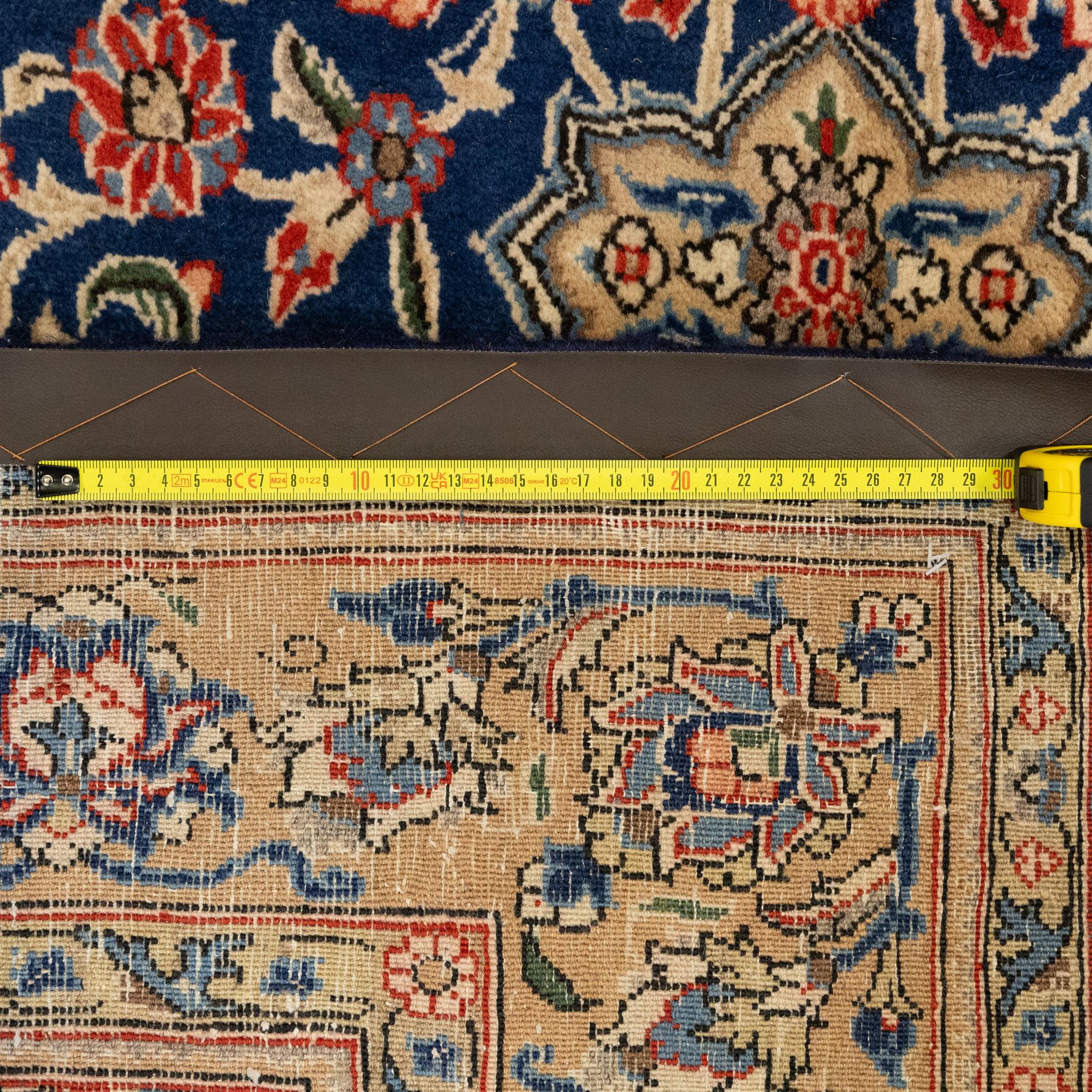 Persian Kashan rug, navy field with lobed central medallion and scrolling floral sprays, ivory spandrels within a palmette and vine border
