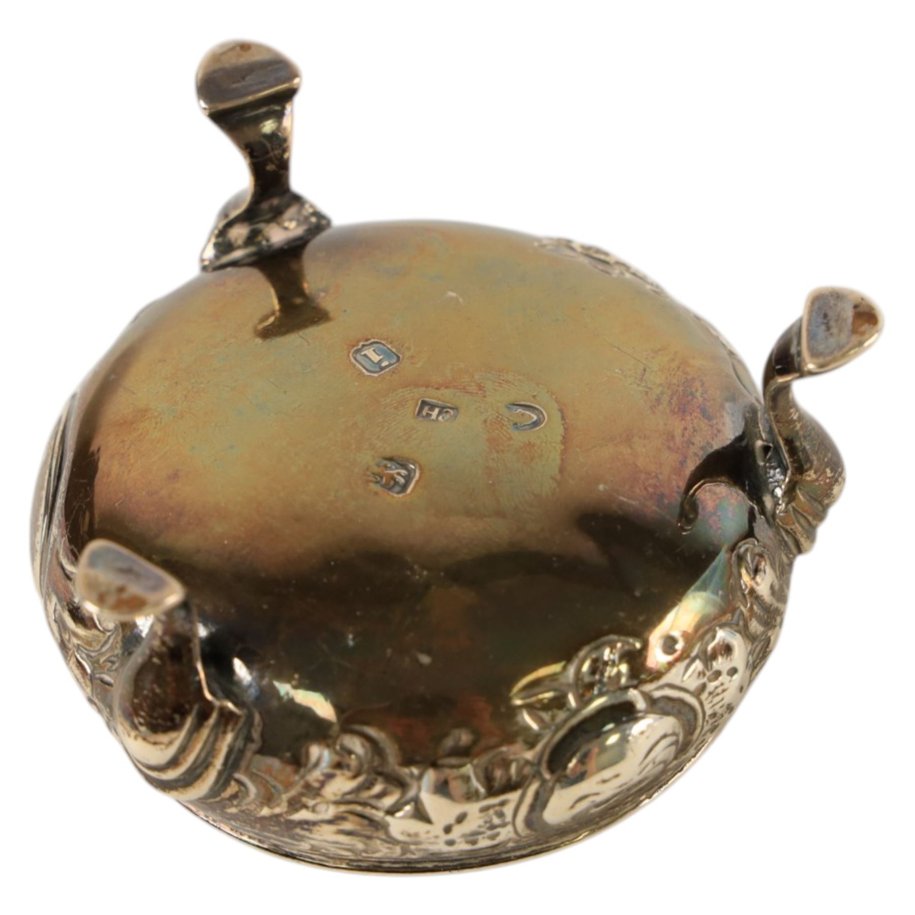 George III silver open salt with embossed floral decoration and a pair of cut glass cruets with silver lids, all hallmarked