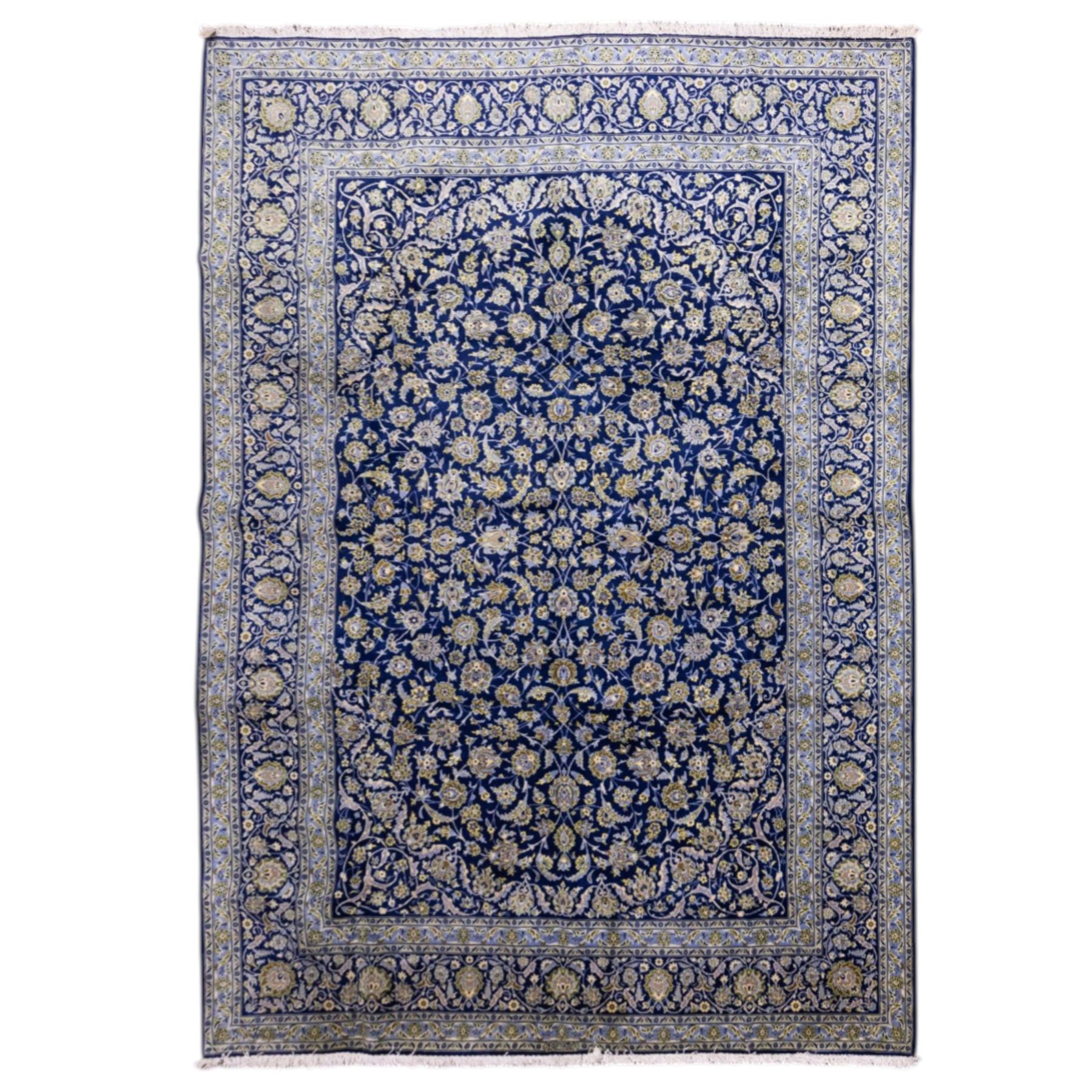 Central Persian Kashan hand-knotted carpet, deep indigo blue field densely decorated with all-over vine, palmette and flowering sprays arranged in a symmetrical pattern enclosed by broad navy border of stylized palmettes, and foliate vine decoration between multiple guard stripes, with cotton fringe ends 