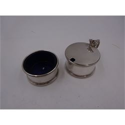 1930s silver part cruet set, comprising mustard pot and cover and open salt, both of circular drum form with oblique gadrooned rim, the mustard pot with capped scroll handle and palmette thumbpiece, both with blue glass liners, hallmarked London 1935, maker's mark worn and indistinct