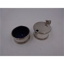1930s silver part cruet set, comprising mustard pot and cover and open salt, both of circular drum form with oblique gadrooned rim, the mustard pot with capped scroll handle and palmette thumbpiece, both with blue glass liners, hallmarked London 1935, maker's mark worn and indistinct