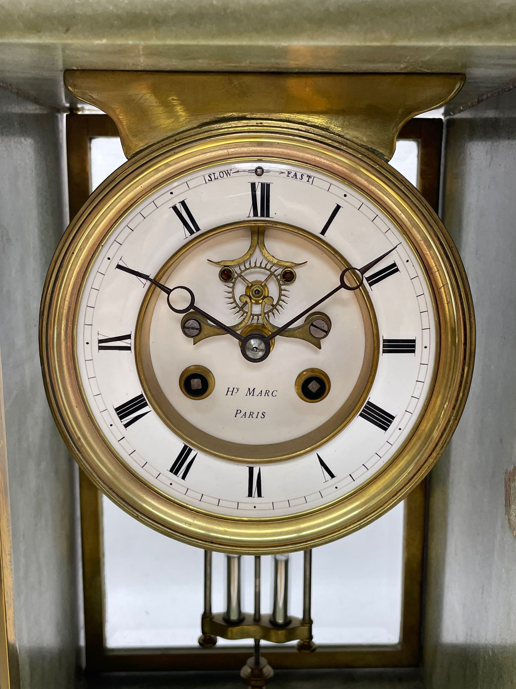 Henry Marc - Early 20th century 8-day French art deco mantle clock c1910, in a green mottled marble case with a stepped flat top and deep moulded plinth, brass framed bevelled front and rear glass doors, two part enamel dial with a visible Brocot deadbeat escapement and pendulum regulation, steel moon hands and Roman numerals, Parisian twin train rack striking movement with a visible twin file mercury pendulum, striking the hours and half-hours on a bell.