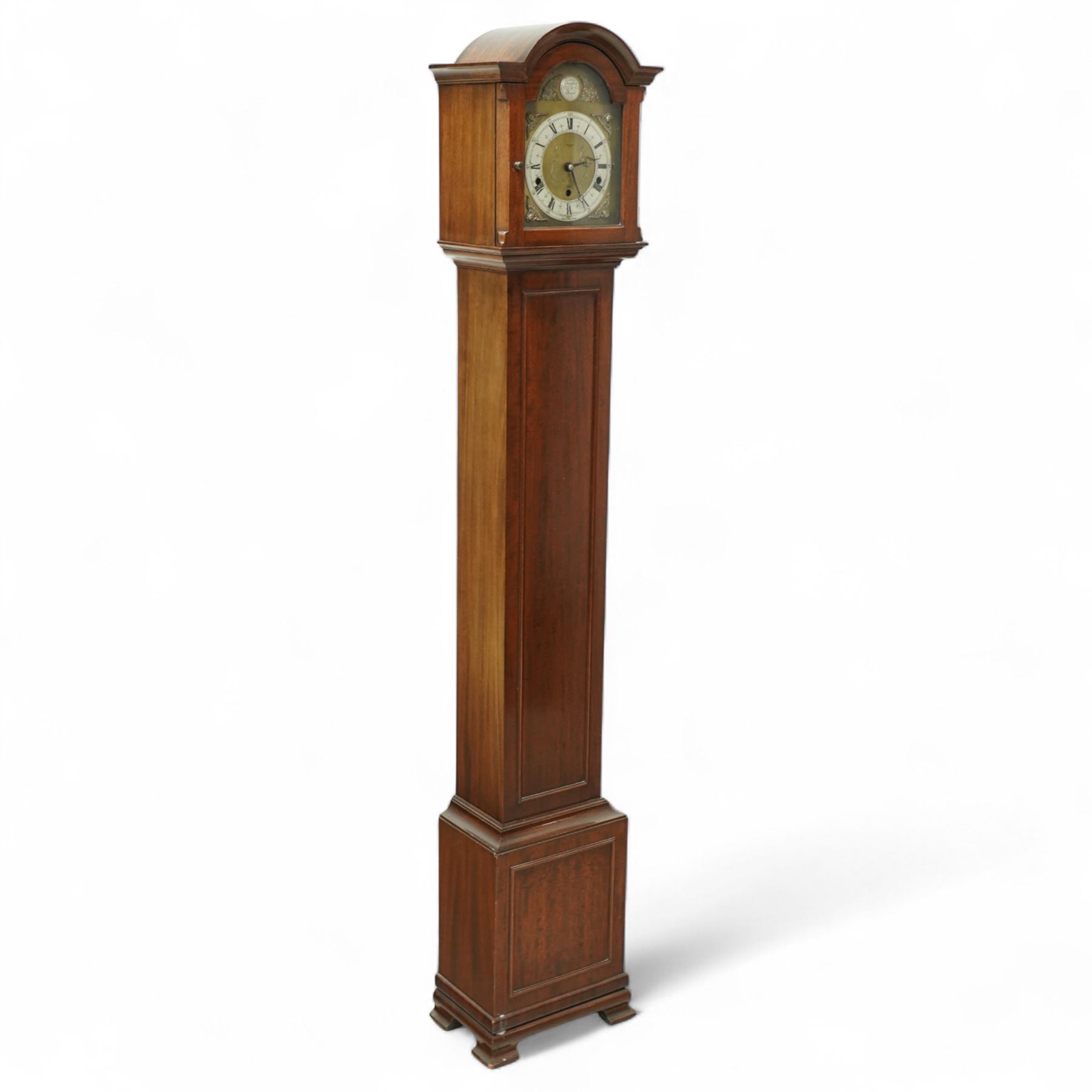 Carmichaels of Hull - mahogany cased 8-day musical grandmother clock c 1930 - with an arched pediment and arched hood, full-length trunk door on a short plinth raised on bracket feet, brass dial signed Tempus Fugit and Carmichaels of Hull with cast spandrels, matted dial centre and silvered chapter with Roman numerals, three train spring-driven movement chiming the quarters and hours on 8 gong rods with Westminster or Whittington chimes, movement stamped Elliott London with pendulum.